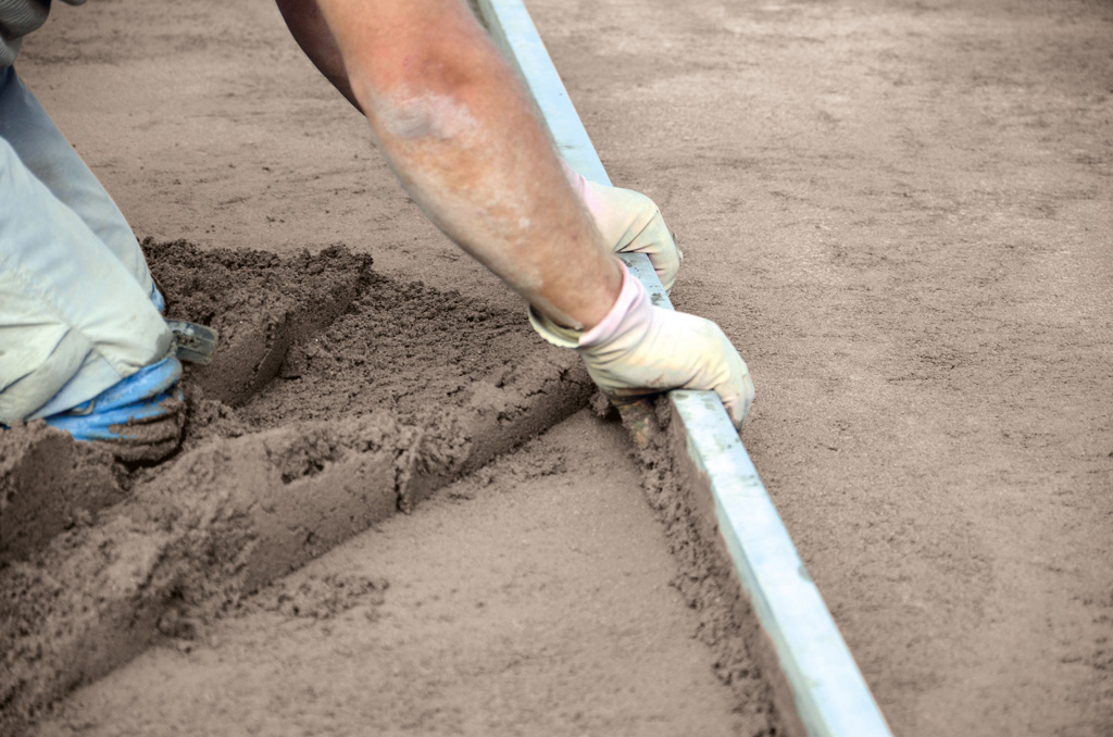 Screeding a floor and levelling it with a tamping screed bar